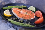 Serving plate with salmon, asparagus, tomatoes and lemon