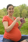 front view of a pregnant woman eating strawberries